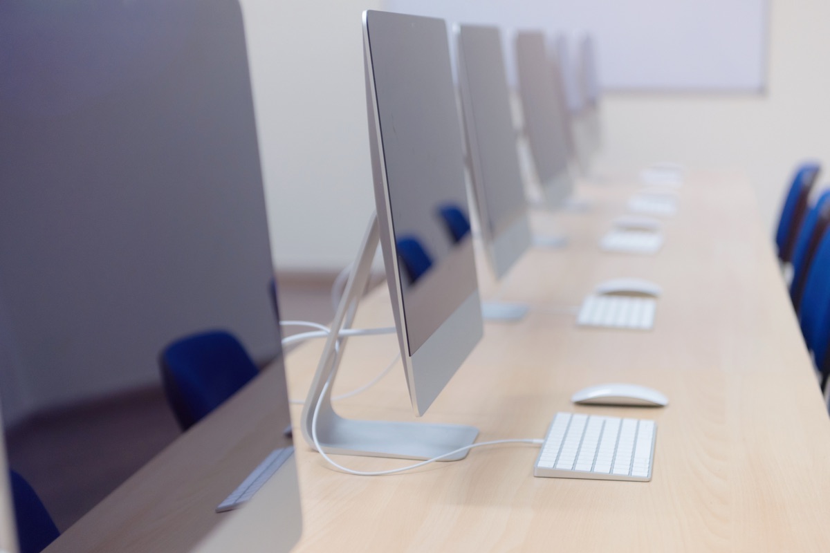 Row of desktop monitors in an empty office