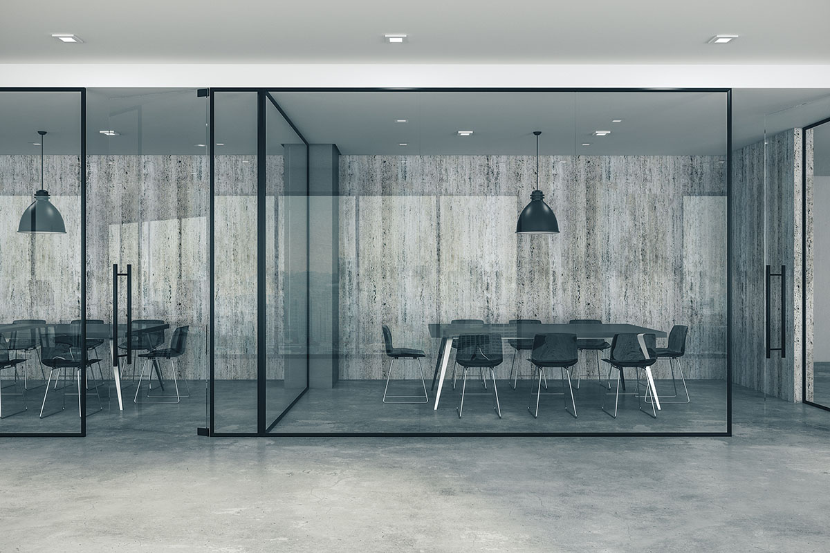 Empty modern office with glass-walled meeting rooms, black chairs around conference tables, pendant lights and polished concrete floors